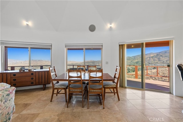 dining space with a healthy amount of sunlight, a mountain view, and vaulted ceiling