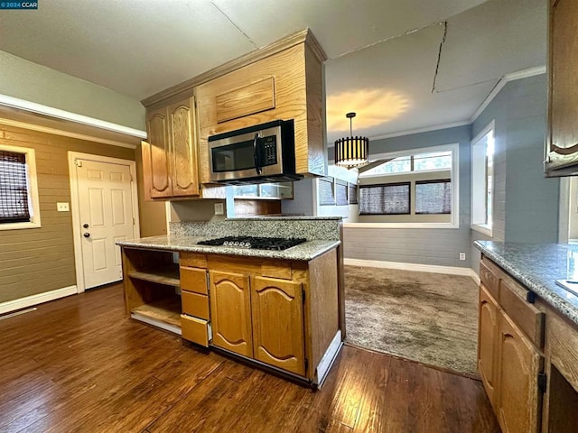 kitchen with dark wood-type flooring, ornamental molding, pendant lighting, and gas cooktop