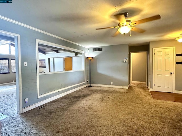 carpeted empty room featuring ceiling fan and crown molding