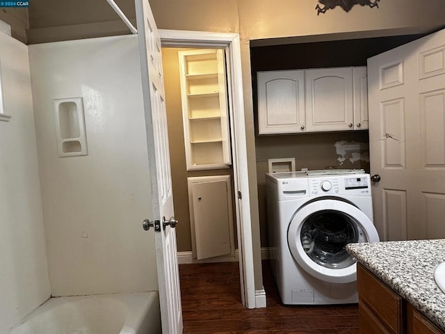 clothes washing area with washer / dryer, cabinets, and dark hardwood / wood-style floors