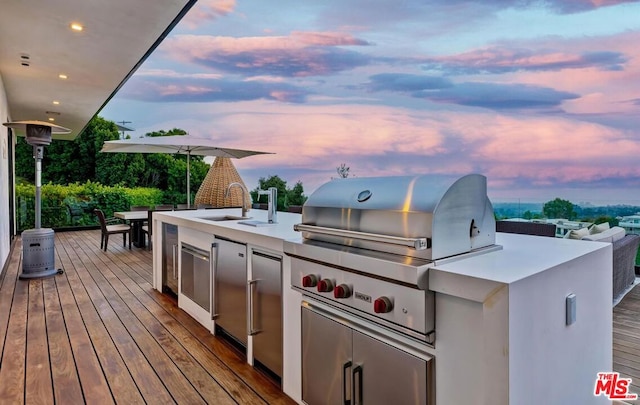 deck at dusk with area for grilling and sink