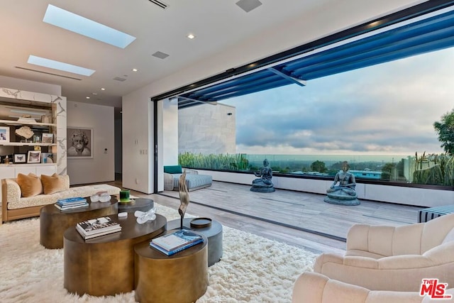 living room featuring a skylight and hardwood / wood-style flooring