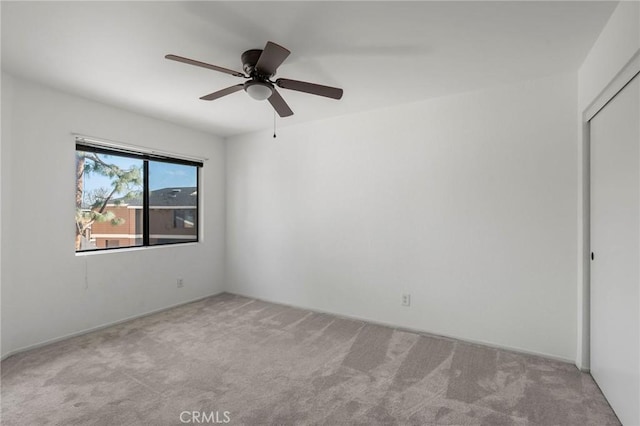 spare room with light carpet and ceiling fan