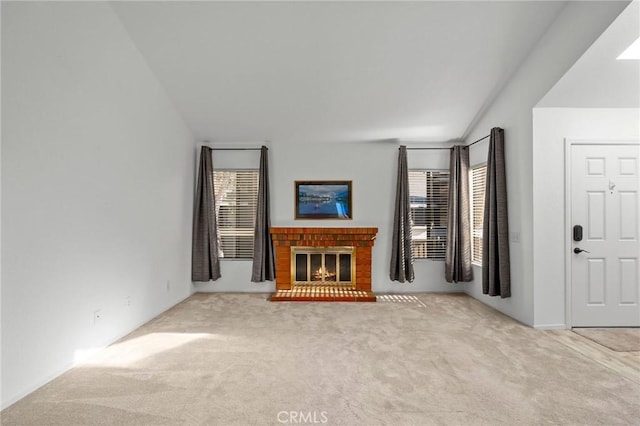 unfurnished living room with light carpet and a brick fireplace