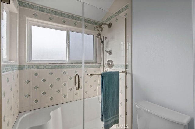 bathroom featuring shower / bath combination with glass door and toilet