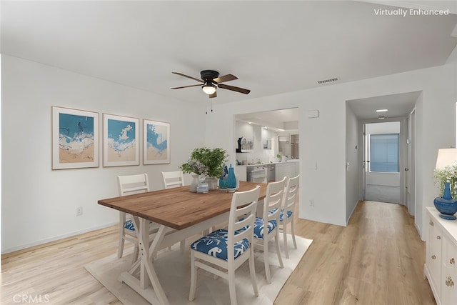 dining space with ceiling fan and light wood-type flooring