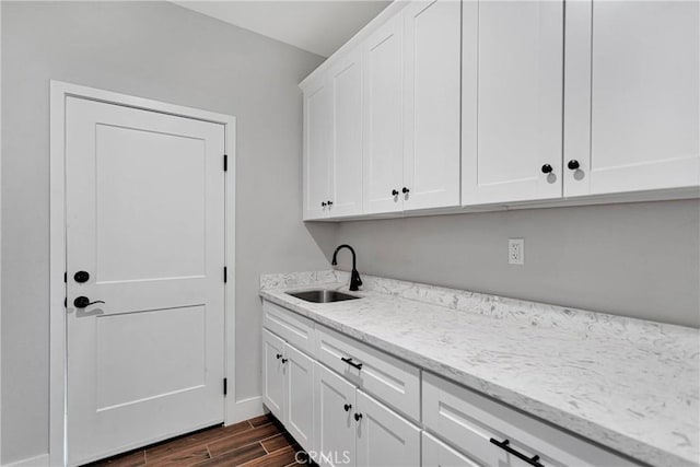 laundry area featuring sink and dark wood-type flooring