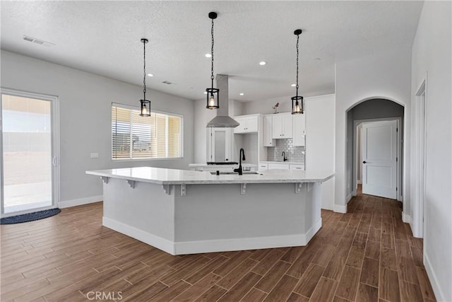 kitchen featuring dark hardwood / wood-style floors, white cabinetry, hanging light fixtures, and a spacious island