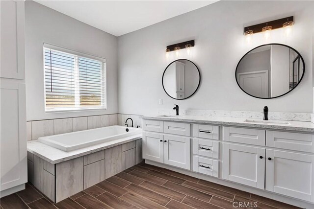 bathroom with hardwood / wood-style floors, vanity, and a bath