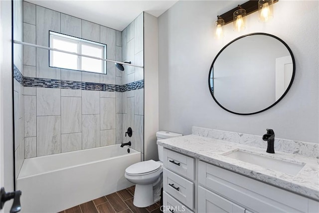 full bathroom with vanity, toilet, tiled shower / bath, and hardwood / wood-style flooring