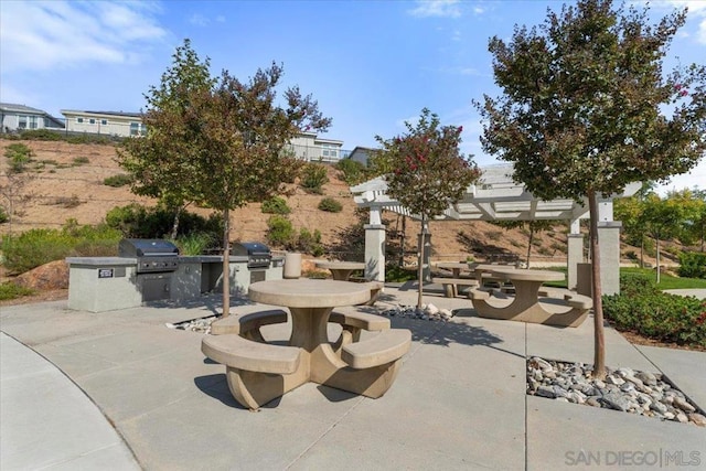 view of patio featuring an outdoor kitchen and a grill