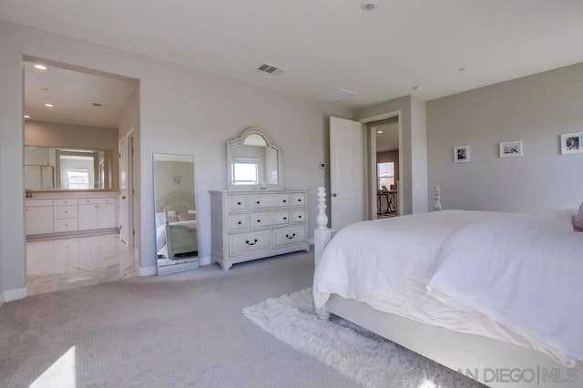 carpeted bedroom featuring multiple windows and ensuite bathroom