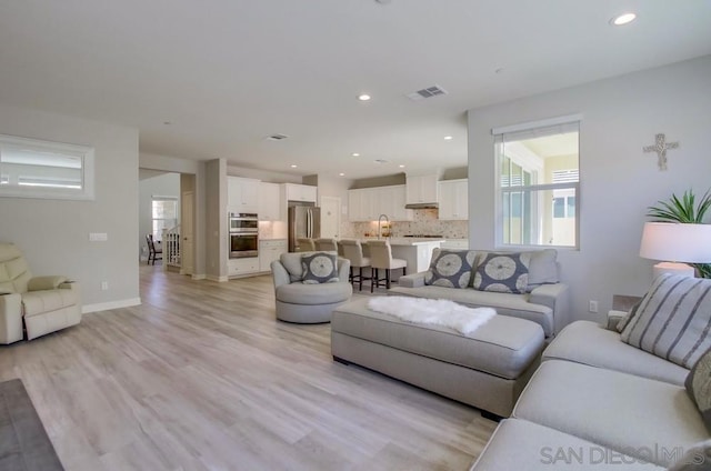 living room with sink and light hardwood / wood-style floors