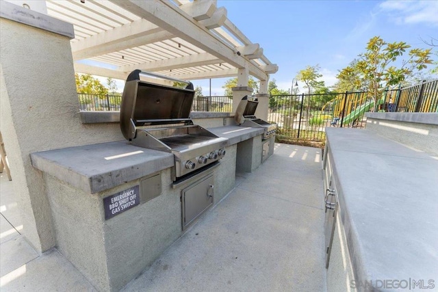 view of patio / terrace featuring area for grilling, a pergola, and an outdoor kitchen