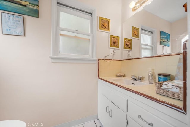 bathroom featuring tile patterned flooring, backsplash, and vanity