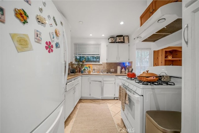 kitchen featuring white cabinetry, light tile patterned flooring, backsplash, and white appliances