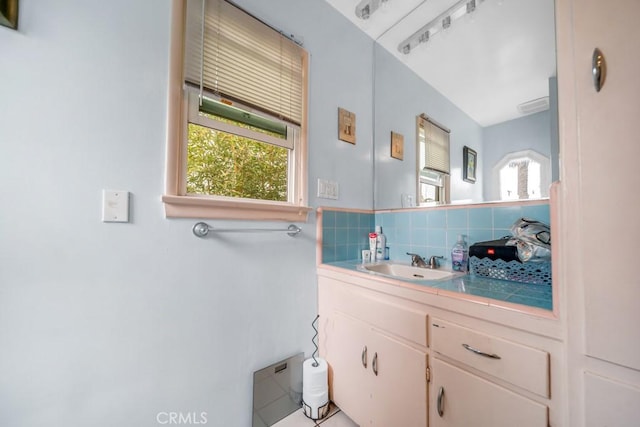 bathroom featuring vanity, backsplash, and a healthy amount of sunlight