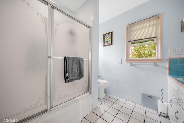 full bathroom with tile patterned flooring, vanity, bath / shower combo with glass door, and toilet