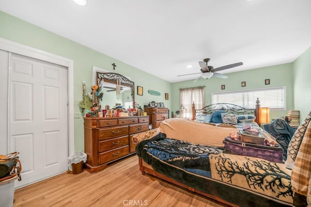 bedroom with light hardwood / wood-style flooring, a closet, and ceiling fan