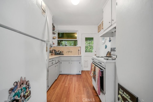 kitchen with sink, white appliances, white cabinets, and light wood-type flooring