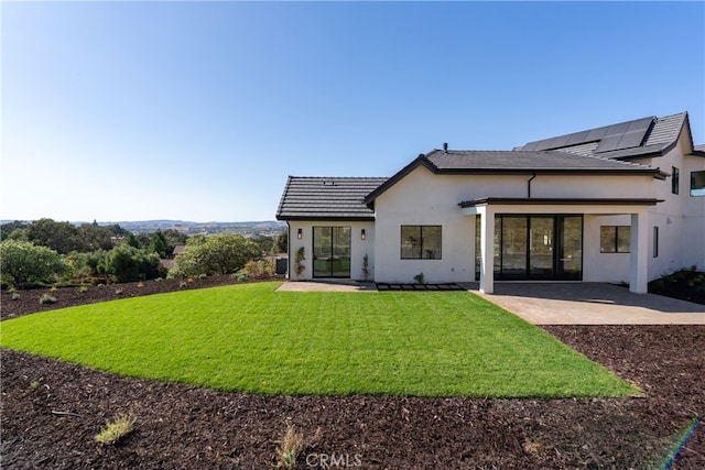 back of house with a patio and a yard