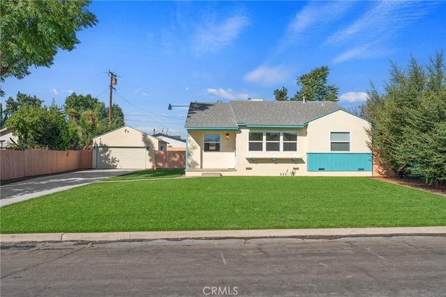 view of front of house with fence, a detached garage, a front lawn, and stucco siding