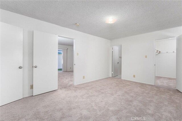 carpeted empty room with a textured ceiling