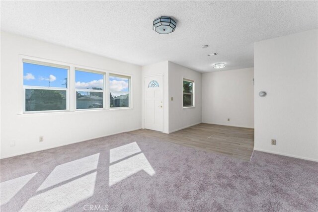 carpeted spare room with a textured ceiling