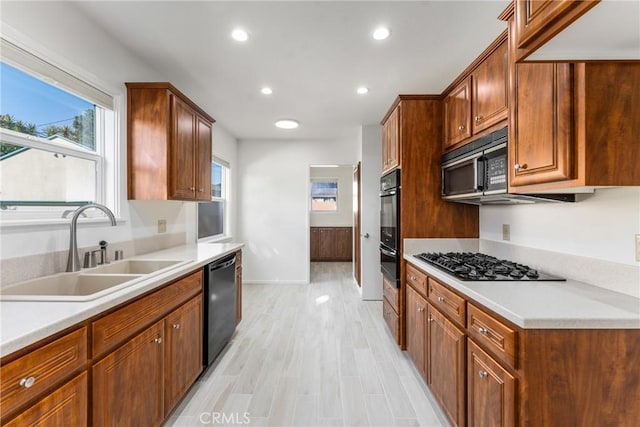 kitchen featuring sink, black appliances, and light wood-type flooring