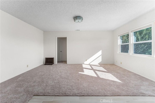 carpeted empty room with visible vents and a textured ceiling