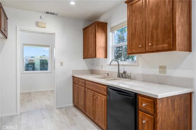 kitchen featuring dishwasher, a sink, visible vents, and brown cabinets