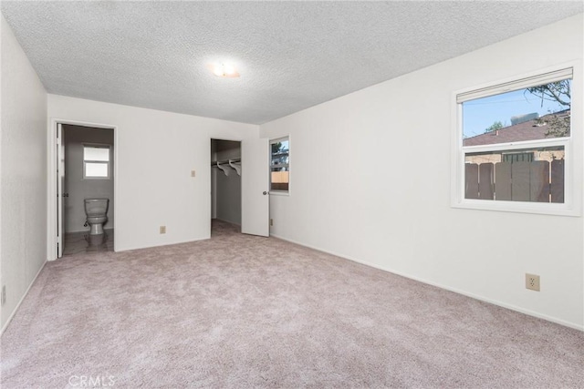 unfurnished room featuring a textured ceiling and carpet