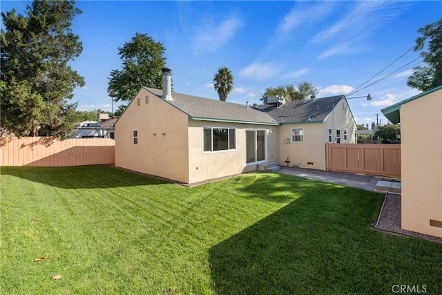 back of property featuring a patio, a yard, fence, and stucco siding