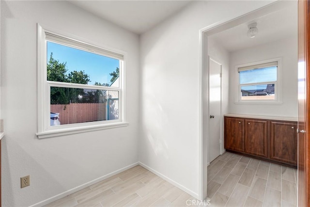 interior space featuring light wood finished floors and baseboards