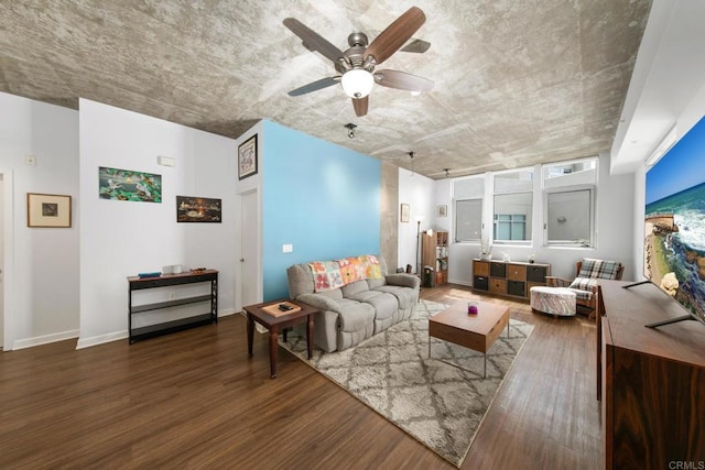 living room featuring dark wood-style floors, baseboards, and a ceiling fan