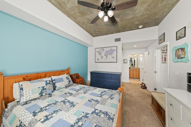 bedroom featuring light carpet, connected bathroom, visible vents, and a ceiling fan