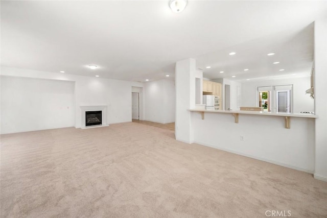 unfurnished living room featuring light carpet