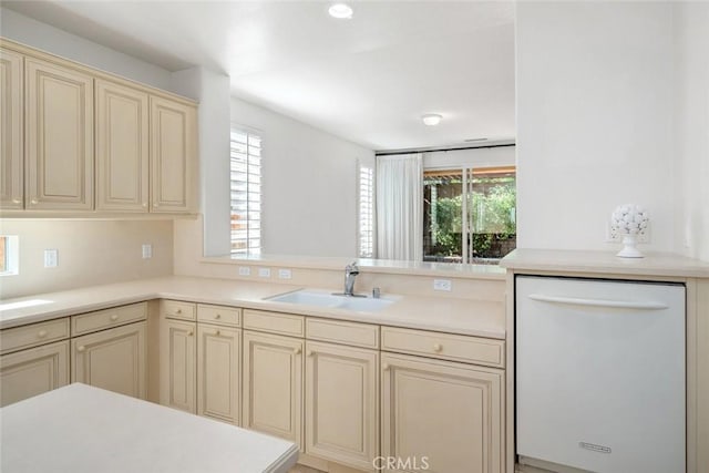 kitchen featuring kitchen peninsula, sink, dishwasher, and cream cabinetry