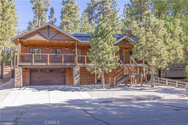 log-style house featuring a garage and a porch