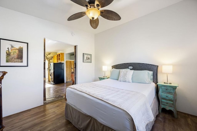 bedroom with ceiling fan, stainless steel refrigerator, and dark hardwood / wood-style floors