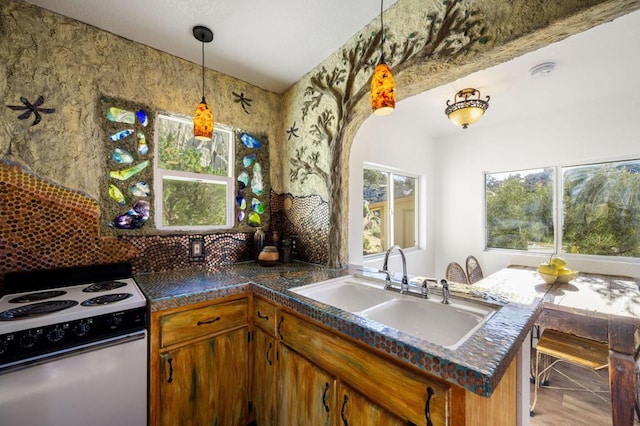 kitchen featuring wood-type flooring, sink, kitchen peninsula, hanging light fixtures, and white electric range