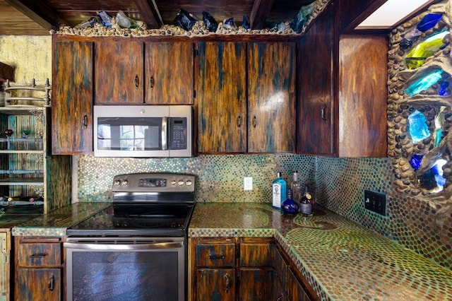 kitchen with appliances with stainless steel finishes and backsplash