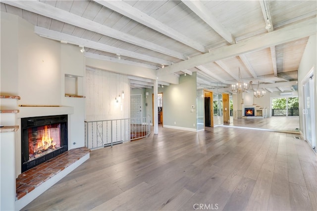 unfurnished living room with lofted ceiling with beams, wood-type flooring, and wooden ceiling