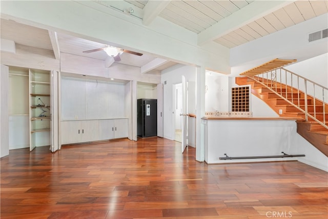 unfurnished living room featuring beamed ceiling, dark wood-type flooring, wood ceiling, and ceiling fan