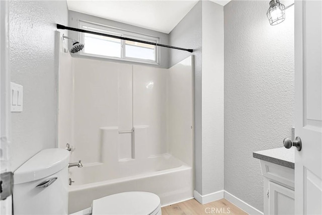 full bathroom featuring hardwood / wood-style floors, vanity, shower / bathtub combination, and toilet