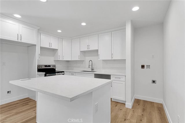 kitchen with white cabinets, a kitchen island, stainless steel range with electric cooktop, and sink