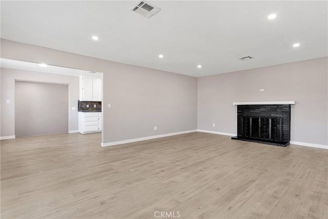 unfurnished living room with light hardwood / wood-style floors and a fireplace