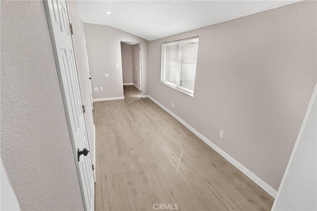 empty room featuring light hardwood / wood-style floors and lofted ceiling