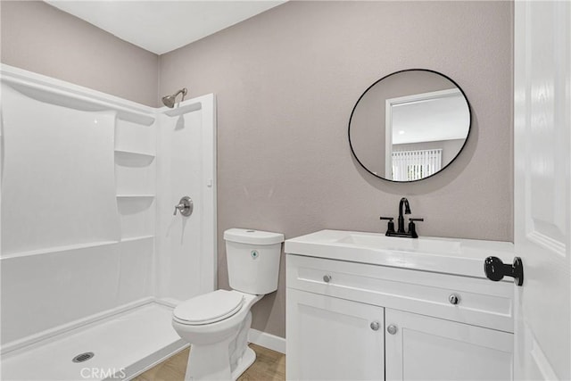 bathroom with vanity, toilet, and a shower