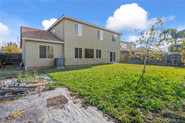 rear view of house with a lawn and central AC